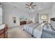 Bright and airy main bedroom featuring neutral décor, ceiling fan, and large windows at 3096 Great Banyan Way, Wesley Chapel, FL 33543