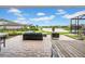 Inviting covered patio with comfortable seating overlooking a lake and landscaped backyard at 3096 Great Banyan Way, Wesley Chapel, FL 33543