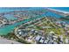 Expansive aerial view of waterfront community, featuring lush landscaping, tennis courts, and numerous canals and waterways at 3210 E Maritana Dr, St Pete Beach, FL 33706