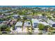 Aerial view of a charming home with a pool, gazebo, and solar panels in a neighborhood near a park and the ocean at 3210 E Maritana Dr, St Pete Beach, FL 33706