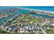 Aerial showcasing neighborhood, tennis courts, intercoastal, and vibrant aquatic waterway in St. Pete Beach, Florida at 3210 E Maritana Dr, St Pete Beach, FL 33706