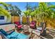 Charming backyard seating area featuring comfortable wicker chairs and a small table nestled among palm trees at 3210 E Maritana Dr, St Pete Beach, FL 33706
