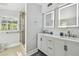 Bathroom featuring a double sink vanity, modern lighting, and a glass-enclosed shower at 3210 E Maritana Dr, St Pete Beach, FL 33706