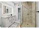 This modern bathroom has a glass shower and a vanity with a white countertop and plenty of storage space at 3210 E Maritana Dr, St Pete Beach, FL 33706