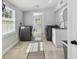 Spacious laundry room with modern washer and dryer, storage, and tile flooring at 3210 E Maritana Dr, St Pete Beach, FL 33706