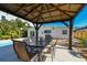Inviting outdoor patio with a covered gazebo, dining set, and views of the lush backyard and refreshing pool at 3210 E Maritana Dr, St Pete Beach, FL 33706