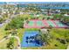 This aerial showcases a playground and tennis courts in a Gathering friendly park with mature trees and landscaping at 3210 E Maritana Dr, St Pete Beach, FL 33706
