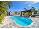Enjoy this kidney shaped pool and patio with outdoor dining in a landscaped yard, perfect for entertaining or relaxation at 3210 E Maritana Dr, St Pete Beach, FL 33706