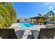 Enjoy this kidney shaped pool and patio with outdoor dining in a landscaped yard, perfect for entertaining or relaxation at 3210 E Maritana Dr, St Pete Beach, FL 33706