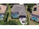Aerial view of the home showing a screened-in pool, fire pit, and surrounding landscape at 3212 Sunset Lakes Blvd, Land O Lakes, FL 34638