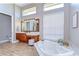 Bathroom with a tub, dual vanities, tile floors, and lots of natural light at 3212 Sunset Lakes Blvd, Land O Lakes, FL 34638