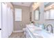 Bright bathroom features a double marble vanity, updated fixtures, toilet, and shower with curtain at 3212 Sunset Lakes Blvd, Land O Lakes, FL 34638