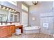 Bathroom with dual vanities, a soaking tub, tiled floors, and natural light at 3212 Sunset Lakes Blvd, Land O Lakes, FL 34638