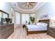 Bedroom with wood flooring, decorative trey ceiling, large windows, and neutral tones at 3212 Sunset Lakes Blvd, Land O Lakes, FL 34638