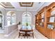 Elegant dining room with hardwood table, chairs, built-in wood shelving, and natural light from a large window at 3212 Sunset Lakes Blvd, Land O Lakes, FL 34638