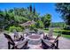 Gather around the fire pit, surrounded by lush greenery, with seating for all at 3212 Sunset Lakes Blvd, Land O Lakes, FL 34638