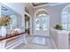 Inviting foyer with elegant tile flooring, arched doorways, and a decorative table with floral arrangement at 3212 Sunset Lakes Blvd, Land O Lakes, FL 34638