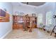 Spacious office with custom wood built-ins, tray ceilings, and a round table with comfortable seating at 3212 Sunset Lakes Blvd, Land O Lakes, FL 34638