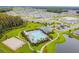 Overhead view of a community featuring a pool, tennis courts, a lake, and green spaces at 32721 Brooks Hawk Ln, Wesley Chapel, FL 33543
