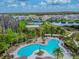 Aerial view showcasing a community pool surrounded by lounge chairs and palm trees at 32721 Brooks Hawk Ln, Wesley Chapel, FL 33543