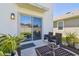 Back patio and sliding glass doors with outdoor seating and well manicured landscaping at 32721 Brooks Hawk Ln, Wesley Chapel, FL 33543
