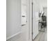 Hallway leading to bedroom with desk, TV, and dresser with neutral paint at 32721 Brooks Hawk Ln, Wesley Chapel, FL 33543