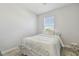 Bright bedroom with ample natural light and wood-look flooring featuring a bed with striped bedding and a decorative stool at 32721 Brooks Hawk Ln, Wesley Chapel, FL 33543