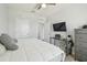 Bedroom with white walls, ceiling fan, queen bed, desk, and gray dresser at 32721 Brooks Hawk Ln, Wesley Chapel, FL 33543