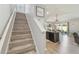 Hallway with carpeted stairs and view of the dining room and kitchen at 32721 Brooks Hawk Ln, Wesley Chapel, FL 33543