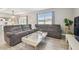 Spacious living room featuring a large sofa, coffee table, and bright light at 32721 Brooks Hawk Ln, Wesley Chapel, FL 33543