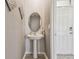 Cozy powder room with pedestal sink and decorative mirror, next to the front door at 32721 Brooks Hawk Ln, Wesley Chapel, FL 33543