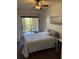 Cozy bedroom with hardwood floors, ceiling fan, and sliding glass door to balcony at 402 S Armenia Ave # 127, Tampa, FL 33609