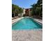 Inviting community swimming pool with lounge chairs surrounded by tropical trees and landscaping at 402 S Armenia Ave # 127, Tampa, FL 33609