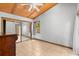 Bright bedroom with wood plank ceiling, ceiling fan, and a large mirrored closet with tile flooring at 407 Indiana Ave, Crystal Beach, FL 34681