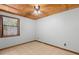 Neutral bedroom features a wood plank ceiling, ceiling fan, and tile floors in a neutral tone at 407 Indiana Ave, Crystal Beach, FL 34681
