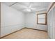 Neutral bedroom features a ceiling fan, and a closet with white wood slat doors with tile floors at 407 Indiana Ave, Crystal Beach, FL 34681
