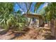 Home exterior surrounded by lush tropical landscaping and privacy fence offers a serene setting at 407 Indiana Ave, Crystal Beach, FL 34681