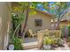 Cozy front porch area with chairs, a small table, and views of the surrounding greenery at 407 Indiana Ave, Crystal Beach, FL 34681