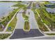 Gated community entrance with paved streets, landscaping, and lake view at 44239 Frontier Dr, Punta Gorda, FL 33982