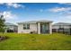 View of the backyard featuring a well-maintained lawn, screened patio, and neat landscaping at 44239 Frontier Dr, Punta Gorda, FL 33982