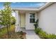 Close up of a home's light-green front door framed by a tiled walkway and lush landscaping at 44239 Frontier Dr, Punta Gorda, FL 33982
