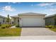 Charming single-story home featuring a two-car garage, manicured lawn, and welcoming facade at 44239 Frontier Dr, Punta Gorda, FL 33982