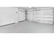 An empty two car garage, featuring a clean epoxy floor and white walls at 44239 Frontier Dr, Punta Gorda, FL 33982