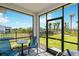 Screened lanai with table and chairs, overlooking a spacious backyard with blue skies at 44239 Frontier Dr, Punta Gorda, FL 33982