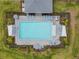 Aerial view of the community pool with lounge chairs and umbrellas, surrounded by a secure fence at 44239 Frontier Dr, Punta Gorda, FL 33982