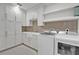 Bright laundry room with white cabinets, tile backsplash, and modern washer and dryer at 455 Pinellas Bayway S # 3B, Tierra Verde, FL 33715