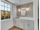 Bright wet bar with white cabinetry, marble countertop, stainless steel sink, and decorative mirror and sconces at 455 Pinellas Bayway S # 3B, Tierra Verde, FL 33715