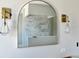 Contemporary bathroom boasts marble tile, modern lighting fixtures, and an arch-shaped mirror at 4716 W Lawn Ave, Tampa, FL 33611
