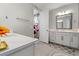 Bright bathroom featuring double sinks, modern fixtures, and a walk-in closet through the doorway at 4784 San Martino Dr, Wesley Chapel, FL 33543