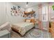 Bright bedroom featuring a bed with floral bedding, a small floating shelf and rug at 4784 San Martino Dr, Wesley Chapel, FL 33543